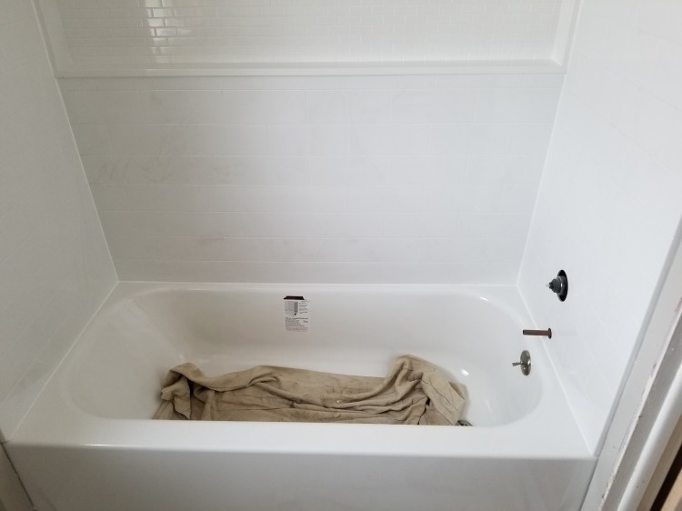 Bathroom tub and surround with large shelf to hold everything you need.